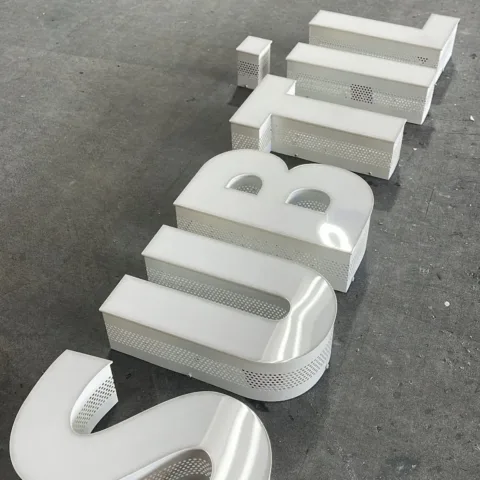 Built-up letter sign, Subtil — perforated white letters
